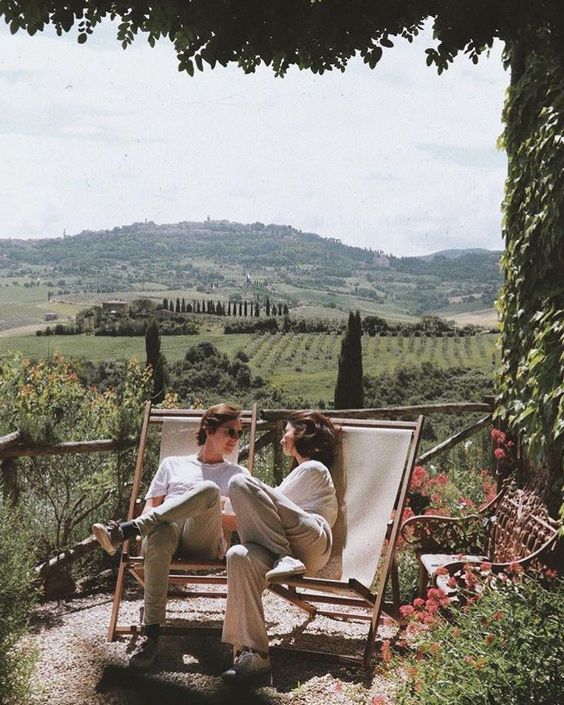 Två personer i solstolar med utsikt över Toscana
