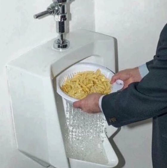 Tallrik pasta sköljs i en urinoar