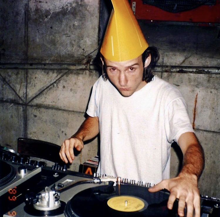 DJ med partyhatt bakom två skivspelare